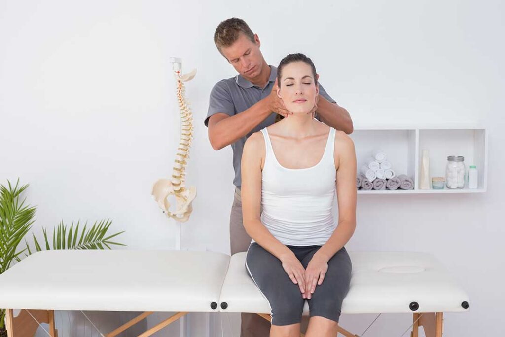 A chiropractor examines a patient's back for spinal alignment and posture issues.
